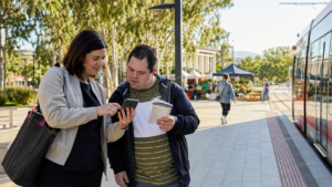 Participant and support worker planning public transport near Canberra light rail