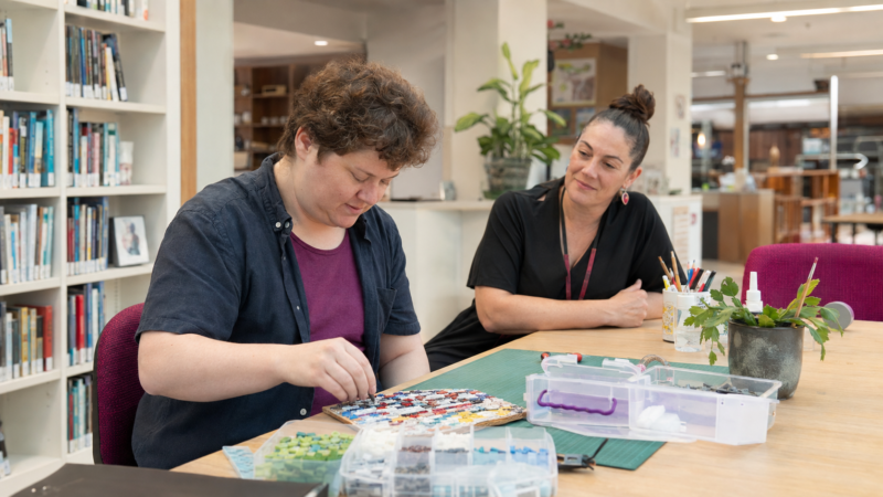 Autistic adult enjoying a low-sensory maker activity in a library